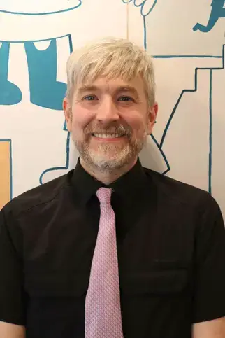 Leo Lovett-Doust, (H)BASc., B.Ed., OCT, a man with white hair wearing a pink tie, Upper School Lead Teacher.