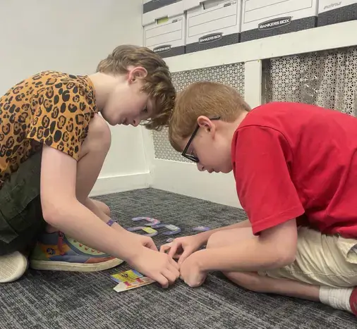 Two boys collaborate on a puzzle, engaging in a supportive and therapeutic activity together.